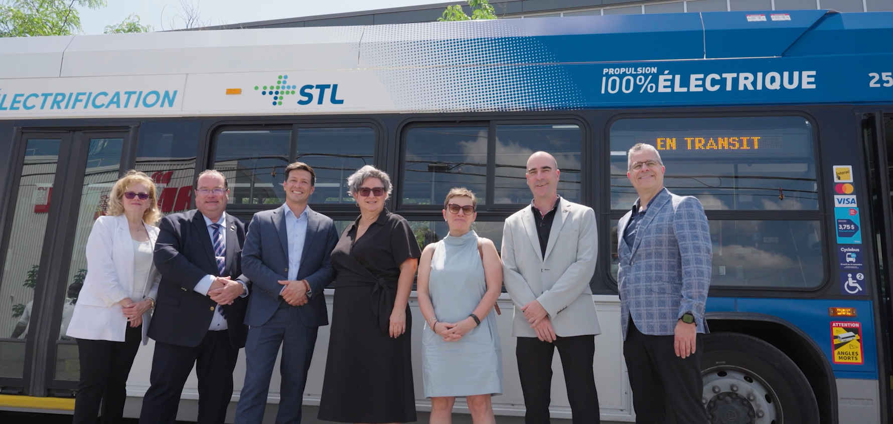Groupe de représentants de la Ville de Laval et de la STL devant un nouveau bus électrique