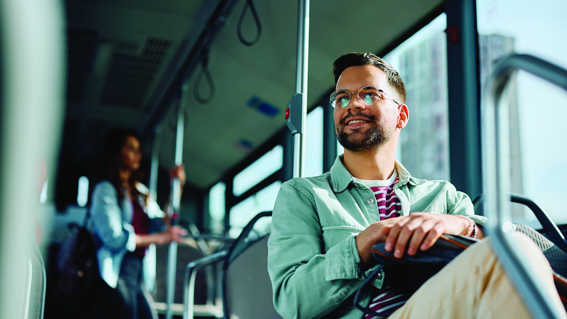 Low angle view of happy man riding in a bus. Copy space.