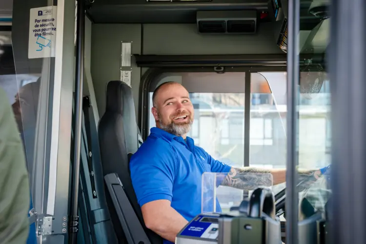 Chauffeur souriant ouvrant la porte de l'autobus