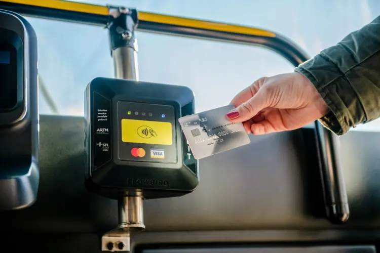 Cliente payant avec sa carte de débit sur le terminal de paiement à bord de l'autobus